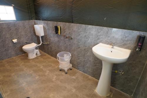 a bathroom with a sink and a toilet at Parvati Baag Camps by Feast Holidays in Saturang