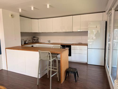 Una cocina con gabinetes blancos y una encimera de madera. en Home Parc by So Homy - 3 Bed Room, 6 People, en Saint-Ouen