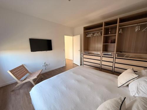 Un dormitorio con una gran cama blanca y un televisor. en Home Parc by So Homy - 3 Bed Room, 6 People, en Saint-Ouen