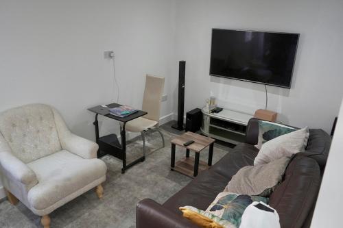 a living room with a couch and a tv at Avonmouth studio apartment in Bristol