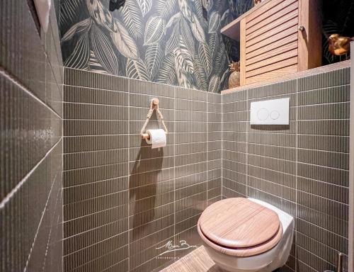 a bathroom with a toilet and a tiled wall at Appartement de Standing Bali 2 Chambres, Terrasse, Wifi, Hyper-Centre Toulon in Toulon