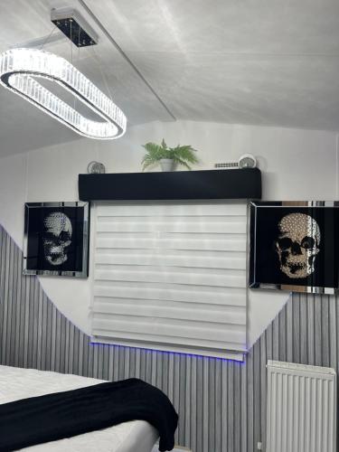 a bedroom with a window with skulls on the wall at Sandylands Holiday Home in Stevenston