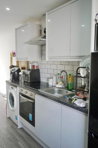 a kitchen with a sink and a washing machine at Avonmouth studio apartment in Bristol