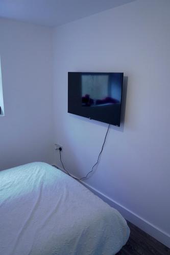 a flat screen tv hanging on a white wall at Avonmouth studio apartment in Bristol