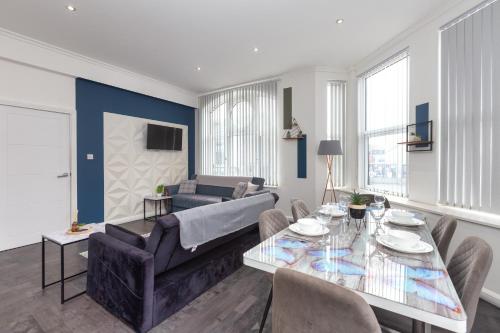 a living room with a couch and a table at Charles Alexander Short Stay - South Pier Apartments in Blackpool