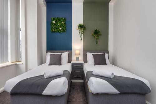 two beds sitting next to each other in a room at Charles Alexander Short Stay - South Pier Apartments in Blackpool