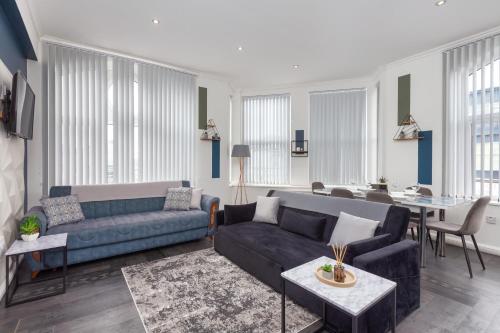 a living room with a couch and a table at Charles Alexander Short Stay - South Pier Apartments in Blackpool