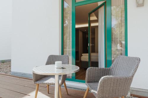 two chairs and a table on a patio at Parkhotel IV Jahreszeiten Kühlungsborn in Kühlungsborn