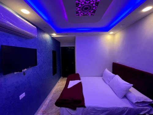 a room with a bed with a blue lighting at Rost pyramids view in Cairo