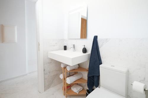 a white bathroom with a sink and a mirror at Isla Bonita Blik by Huskalia in Puerto Naos