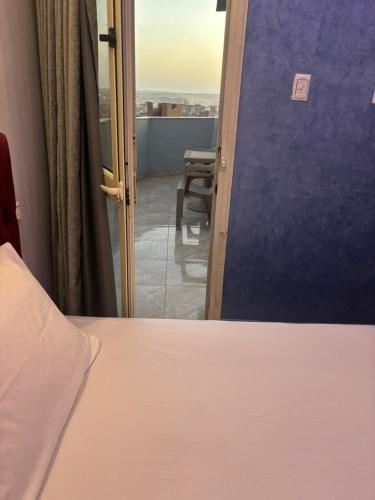 a room with a bed and a view of a balcony at Rost pyramids view in Cairo
