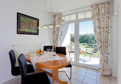 ツィノヴィッツにあるFerienwohnung Haus Roland Whg 26のテーブルと椅子と窓のあるダイニングルーム