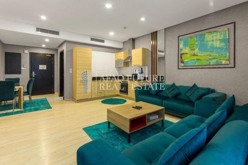 a living room with a blue couch and a table at Vita Tower in Manama
