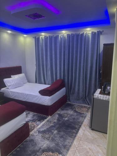 a bedroom with two beds and a purple ceiling at Rost pyramids view in Cairo