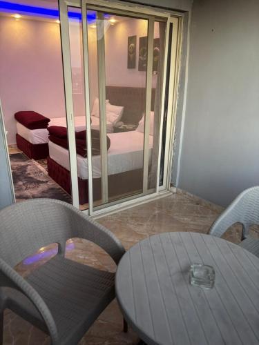 a room with a table and chairs and a bedroom at Rost pyramids view in Cairo