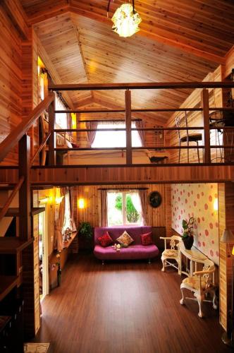 a living room with a purple couch in a wooden house at 近月旭海莊園民宿 in Yanliau