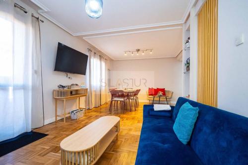 a living room with a blue couch and a table at Nuevo Luanco By Silastur in Gijón