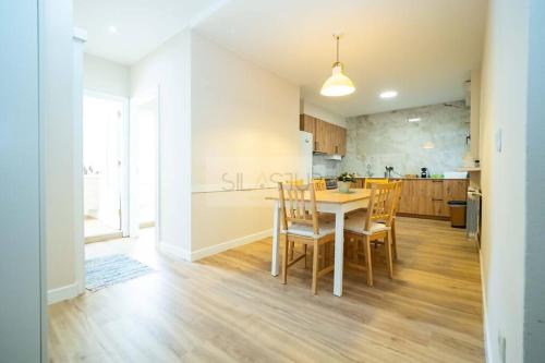 una cucina e una sala da pranzo con tavolo e sedie di Nuevo Luanco By Silastur a Gijón