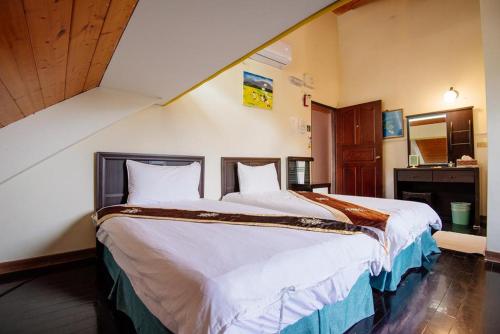 a bedroom with two beds in a room at 近月旭海莊園民宿 in Yanliau