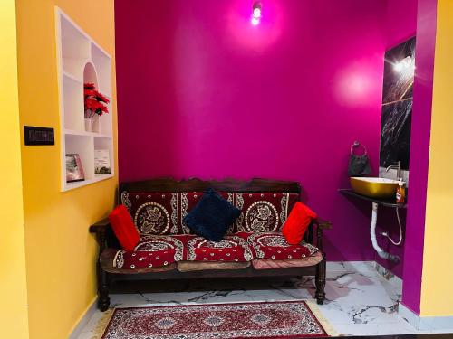 a couch in a room with a pink wall at Coorgsierra in Madikeri