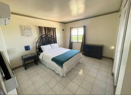 a bedroom with a large bed and a window at Dove Cove Comfort Suites in Rat Island