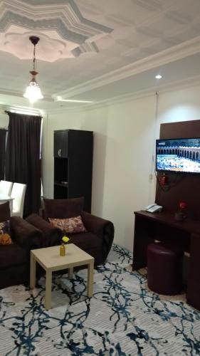 a living room with a couch and a table at عرعر Desert Rose Hotel in Arar
