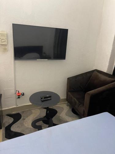 a living room with a couch and a table and a television at Appartement Sewa ACI 2000 in Bamako