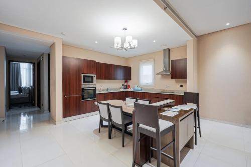 a large kitchen with a table and chairs at Eden Garden Hotel Apartment in Manama