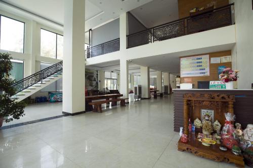 a lobby with a fireplace and stairs in a building at Loan Ngạn Hotel Hải Hòa in Nghi Sơn
