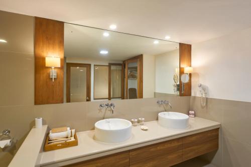 a bathroom with two sinks and a large mirror at The Avenue Regent in Cochin