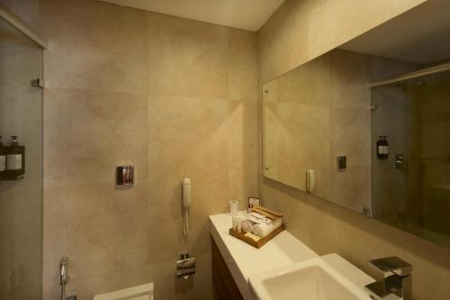 a bathroom with a sink and a mirror at The Avenue Regent in Cochin