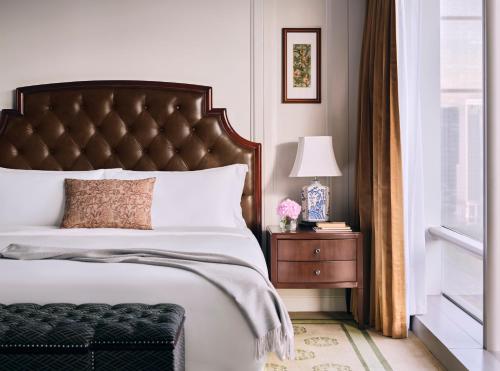 a bedroom with a bed and a table with a lamp at The Langham, Shenzhen in Shenzhen