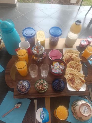 een tafel met een dienblad met eten en wat drankjes bij Riad Villa Nice Tagadirt, Agadir in Agadir
