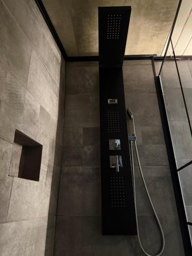 a shower in a bathroom with a black shower head at Secret Factory & Spa in Soultz-Haut-Rhin