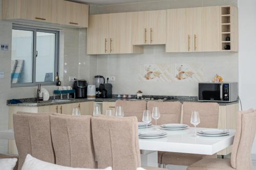 a kitchen with a white table with chairs and a kitchen at Cassoma House in Luanda