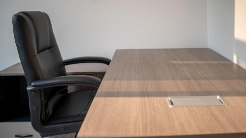 a black chair sitting at a table with a laptop at Cassoma House in Luanda