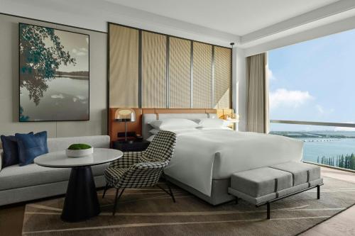 a bedroom with a bed and a couch and a table at Sheraton Kunshan Dianshan Lake in Kunshan