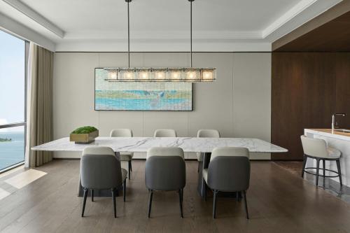 a dining room with a large white table and chairs at Sheraton Kunshan Dianshan Lake in Kunshan