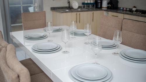 a white table with plates and wine glasses on it at Cassoma House in Luanda