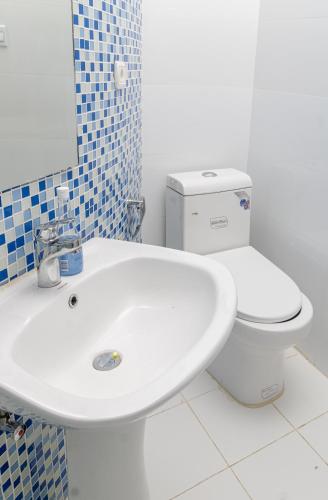 a bathroom with a white sink and a toilet at Cassoma House in Luanda