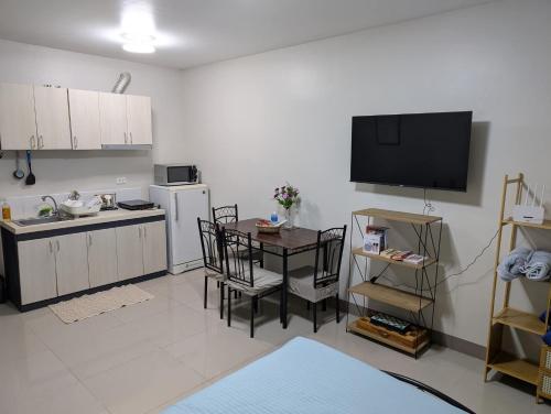 a kitchen with a table and a television in a room at DL's crib in Lo-oc