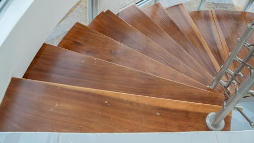 a wooden spiral staircase with a metal rail at Cassoma House in Luanda