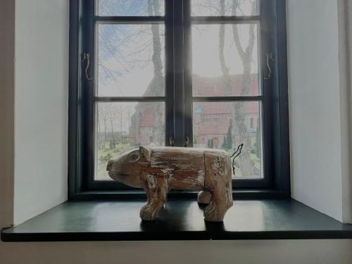 a statue of an elephant sitting in front of a window at Villa Nikolaj - Historisches Pastorat in Fehmarn