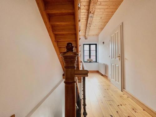 a hallway with a wooden ceiling and a wooden staircase at Villa Nikolaj - Historisches Pastorat in Fehmarn