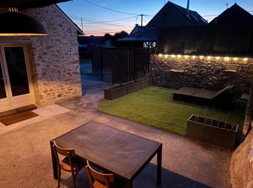 a patio with a table and a bench and a building at La Grange in Savenay