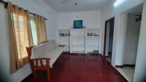 a living room with a couch and a chair at The Corner House by Liz Non Airconditioned in Mahabalipuram