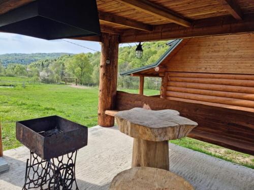 a grill on a patio next to a cabin at Vysoka brama дерев'яний будиночок з чаном in Oriv