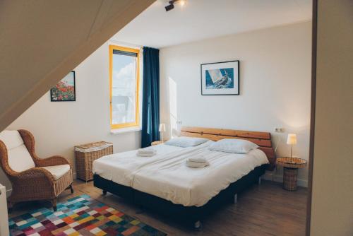 a bedroom with a bed and a chair and a window at Herenhuis geschakeld | 8 personen - Boutique Parc Pharshoeke in Heeg