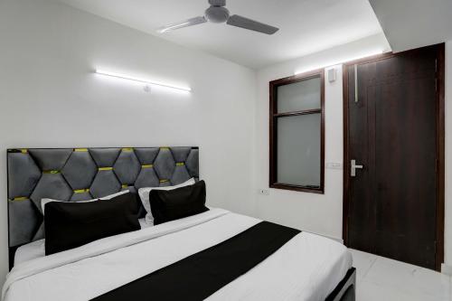 a bedroom with a black and white bed and a window at Collection O 24/7 Hotel in New Delhi
