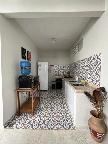 a kitchen with a refrigerator and a table in it at Sunshine Kite Inn in Prea